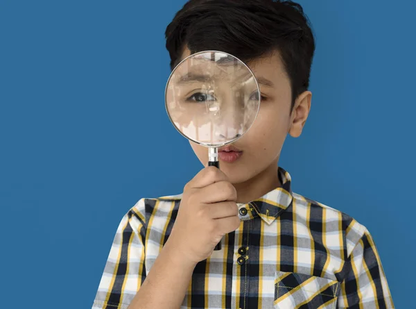 Boy looking in magnifying glass — Stock Photo, Image