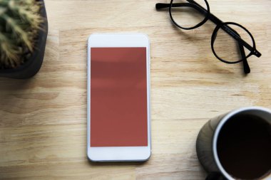 Smartphone, fincan kahve ve gözlük