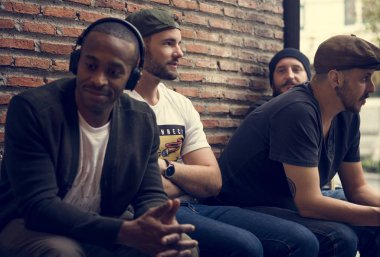 Erkekler birlikte tuğla duvar otur.