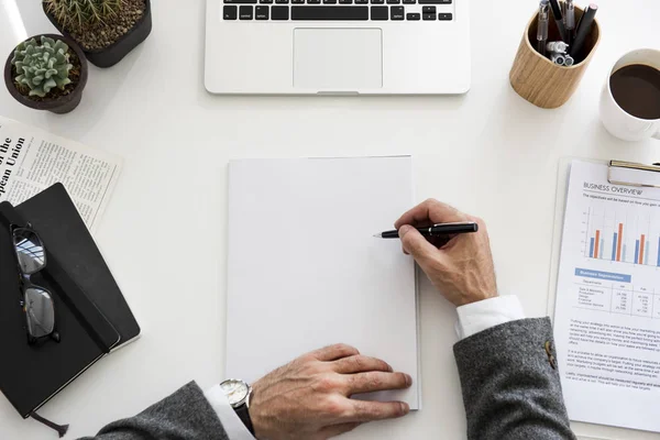 Zakenman die op papier schrijft — Stockfoto