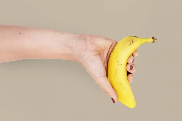 Ręka trzyma banan — Zdjęcie stockowe