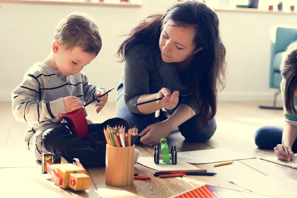 Мать учит сына рисовать — стоковое фото