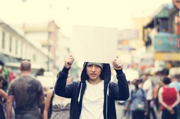Asiático hombre holding vacío cartel al aire libre — Foto de Stock