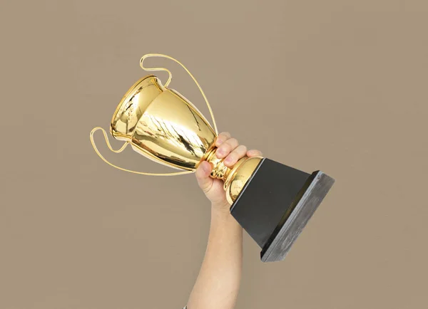 Рука тримає золотий трофей — стокове фото