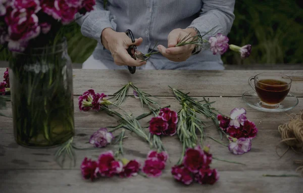 Mujer mayor cortando flores — Foto de Stock