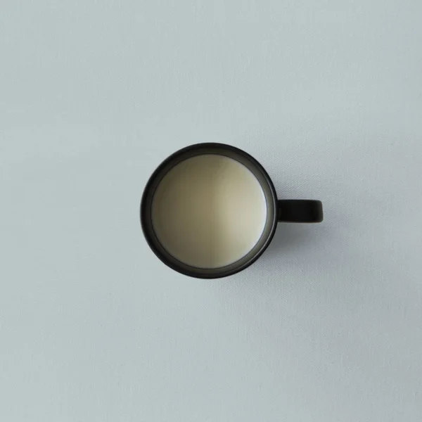 Black cup with milk — Stock Photo, Image