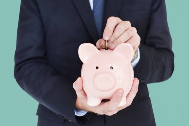piggy banka para koyarak adam
