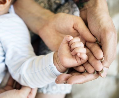 Yeni doğan bebeğin elini tutarak anne