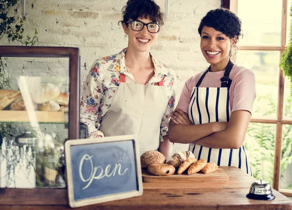 Donne amiche al negozio di panetteria sorridente — Foto Stock