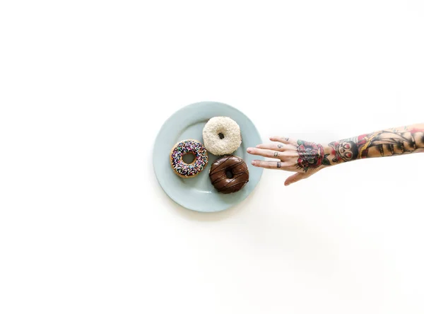Mano que alcanza para donut — Foto de Stock