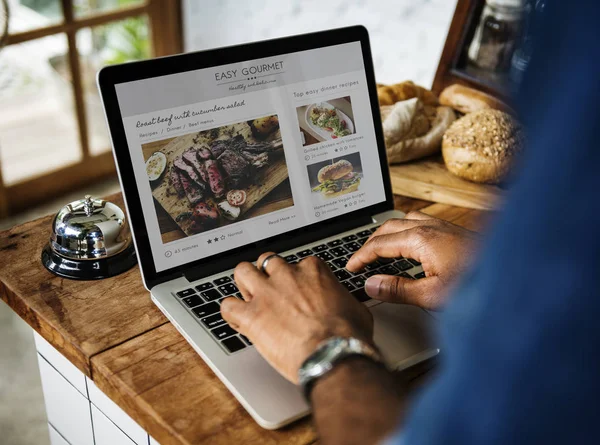 Hombre usando el ordenador portátil en la tienda de pan — Foto de Stock