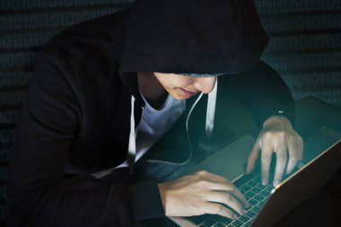 Asyalı çocuk dizüstü kullanarak kapüşonlu 