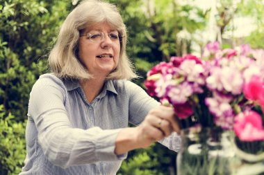 Olgun Bayan çiçek düzenliyor