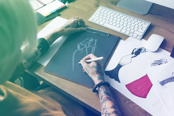 Дизайнерка жінка малює за столом — стокове фото