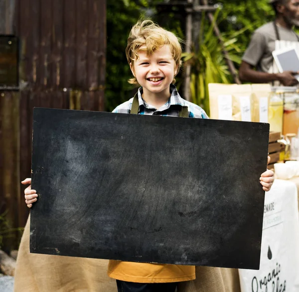 Мальчик, держащий доску с копирайтом — стоковое фото