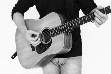 Adam akustik gitar çalıyor.