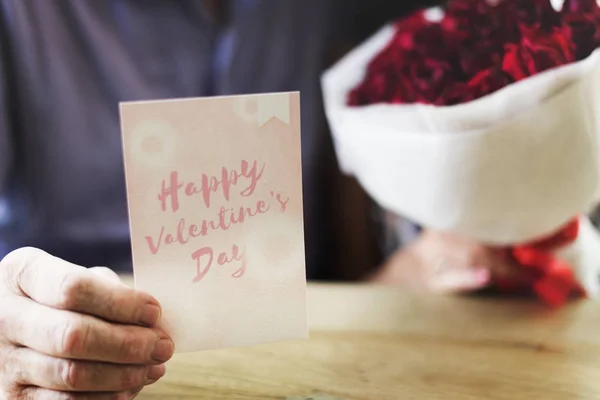 Homem segurando cartão com rosas — Fotografia de Stock