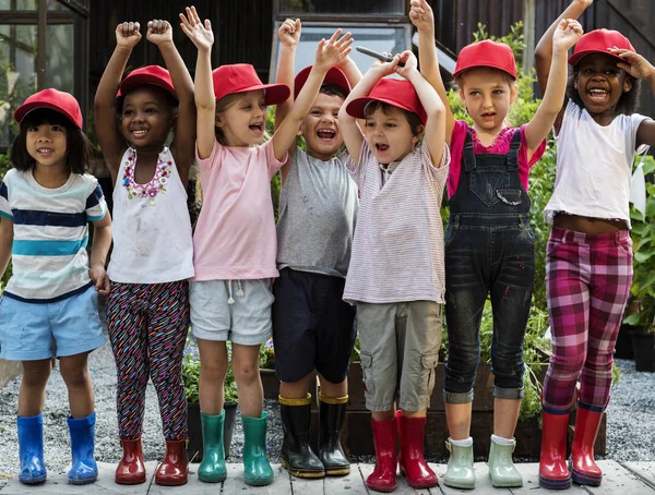 Grupo de niños de jardín de infantes en gorras rojas — Foto de Stock