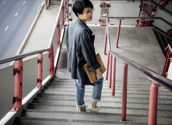 Azjatycki facet schodząc w dół po schodach — Zdjęcie stockowe