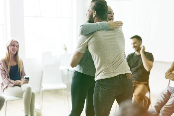 Gente abrazándose en la reunión — Foto de Stock