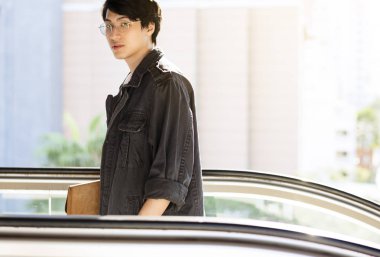 Asya adam yürüyen merdiven kullanarak 