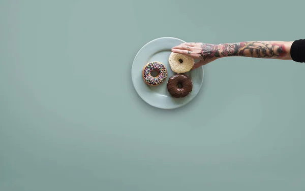 Mano que alcanza para donut — Foto de Stock