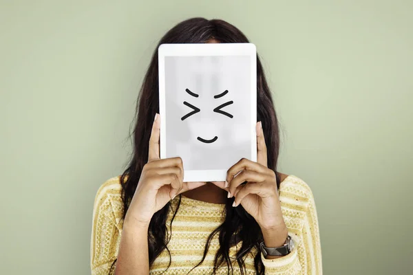 Žena držící digitálním tabletu pokrývající obličej — Stock fotografie