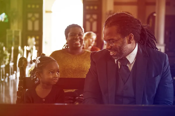 Отец и дочь сидят в церкви — стоковое фото