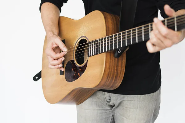 Человек играет на акустической гитаре — стоковое фото