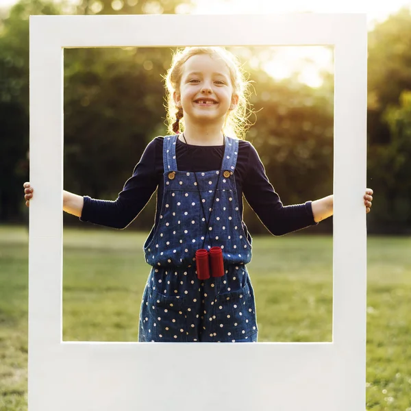 Gadis memegang bingkai putih di taman — Stok Foto