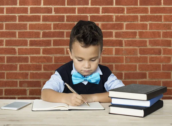 Chłopiec pisania w notesie — Zdjęcie stockowe