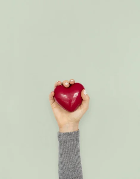 Mão segurando vermelho coração brinquedo — Fotografia de Stock