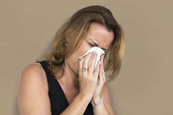 Mujer estornudando en tejido —  Fotos de Stock