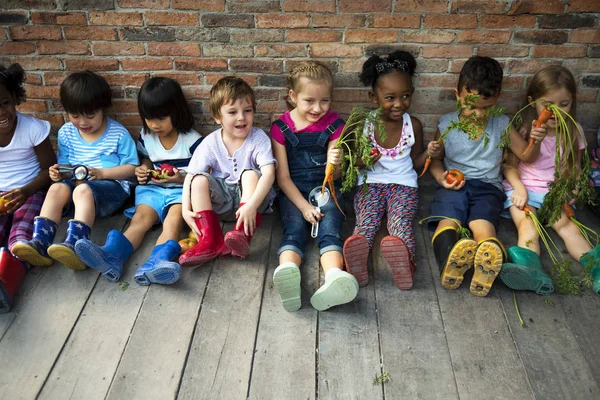 Группа детей из детского сада, сидящих у стены — стоковое фото
