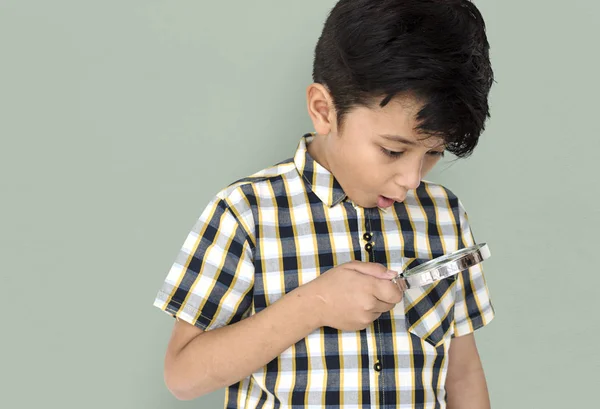 Boy looking in magnifying glass — Stock Photo, Image