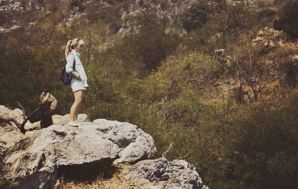 Donna in piedi sulla collina rocciosa — Foto Stock