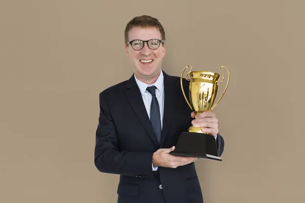 Homem de negócios segurando troféu dourado — Fotografia de Stock