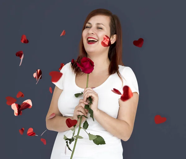 Mujer joven sosteniendo rosa roja — Foto de Stock