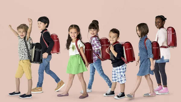 Enfants marchant jusqu'à l'école avec des sacs à dos — Photo