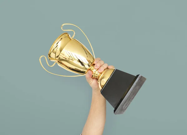 Mão segurando troféu dourado — Fotografia de Stock