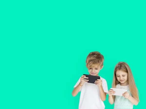 Дети играют в мобильные телефоны — стоковое фото