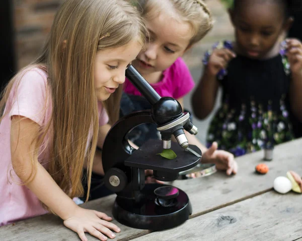 Kid dívky pomocí mikroskopu — Stock fotografie