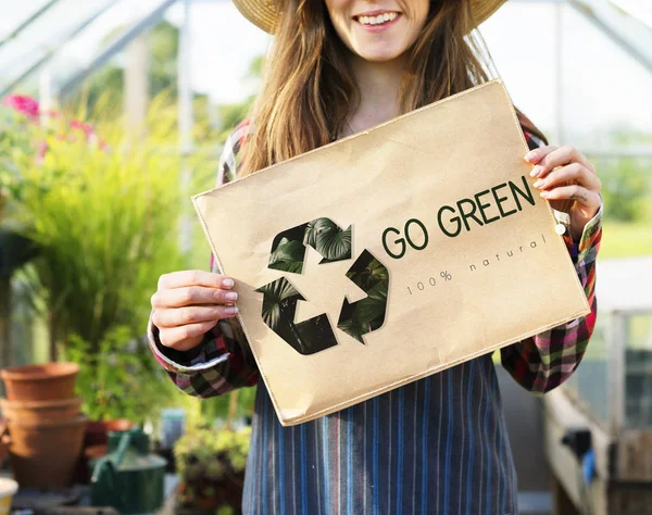 woman holding paper banner in greenhouse