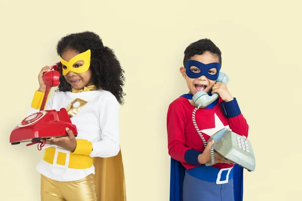 Děti v superhrdina kostýmy na telefony — Stock fotografie