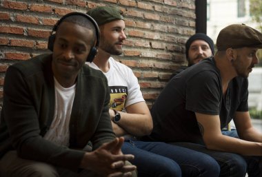 Erkekler birlikte tuğla duvar otur.