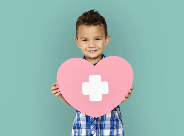 Pojke innehav hjärta med kors — Stockfoto