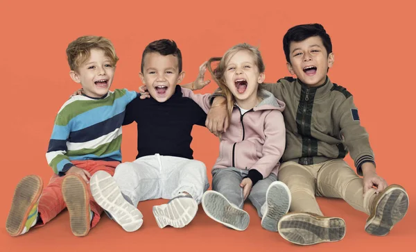 Crianças sorridentes sentadas no chão T — Fotografia de Stock