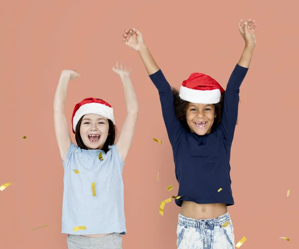 Crianças se divertindo em chapéus de Santa — Fotografia de Stock