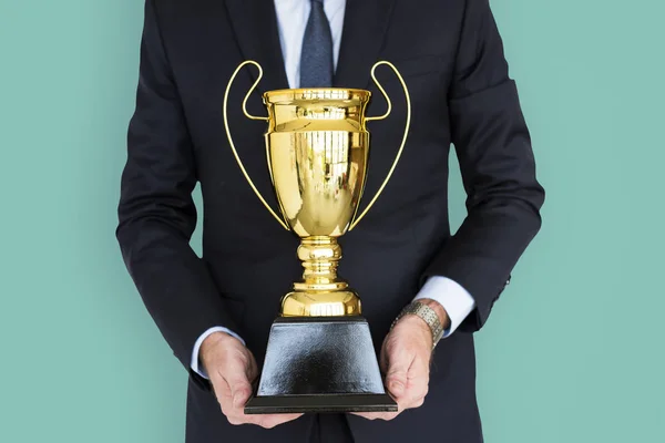 Empresário segurando troféu dourado — Fotografia de Stock