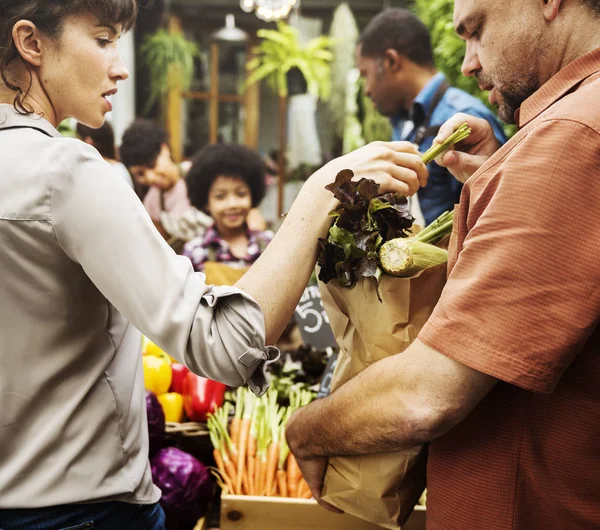 Personas que compran verduras en el mercado — Foto de Stock